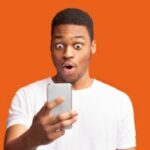 Closeup portrait of surprised african guy looking at phone