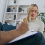 Young woman domestic abuse survivor at doctor's appointment, emotional support and help